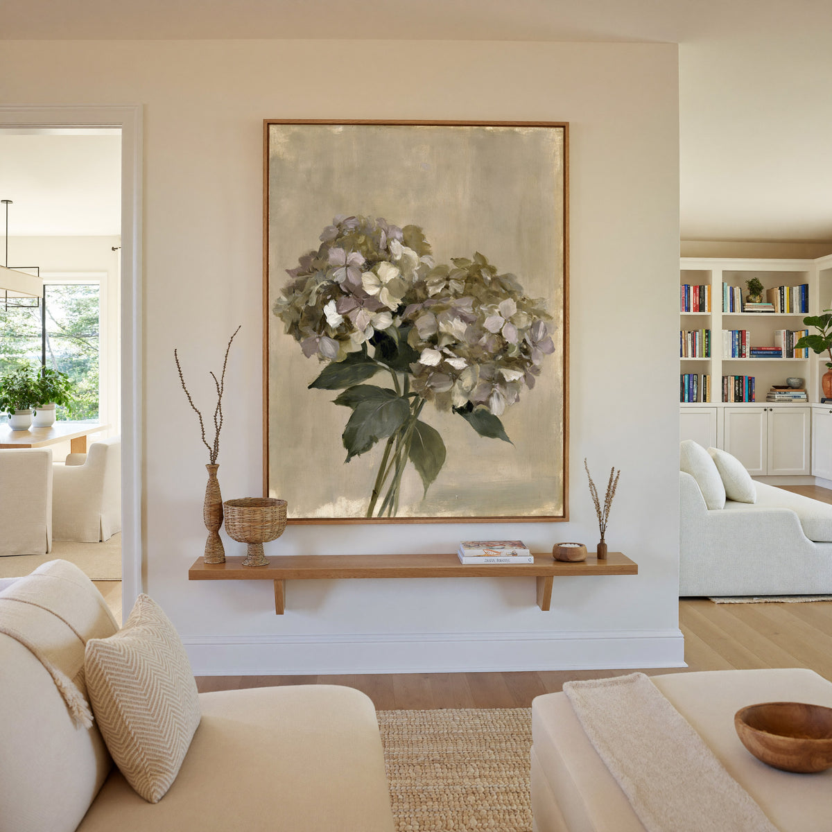 faded hydrangea cluster in cream, mauve, and canvas wall art in an oak frame in a living room