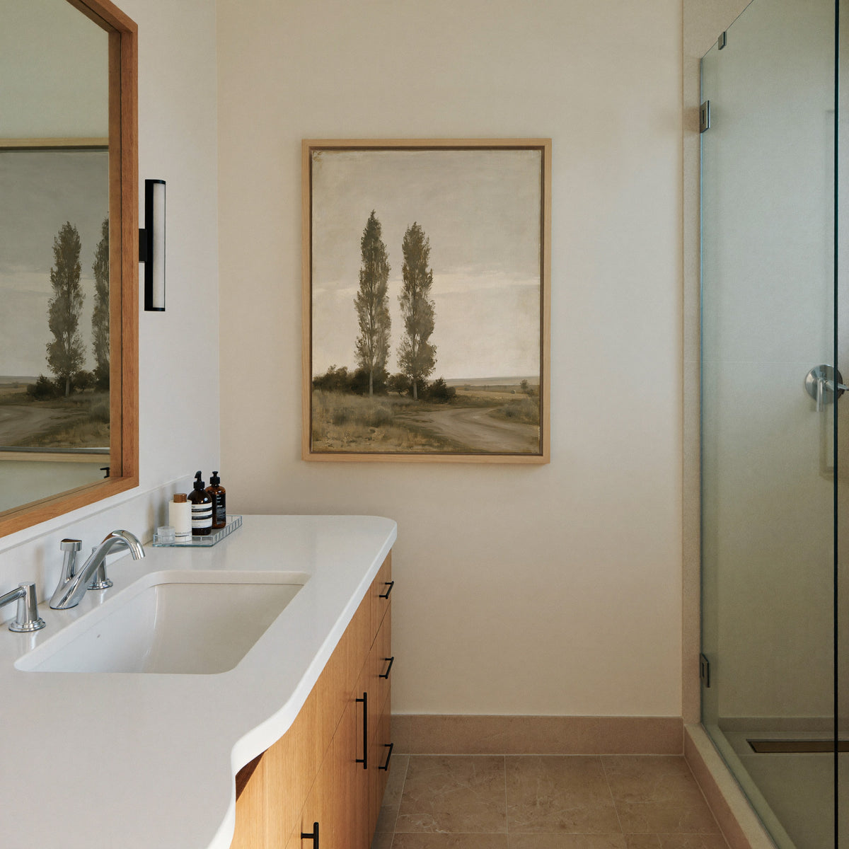 two slender poplar trees beside a canvas wall art in a natural wood frame in a styled room setting
