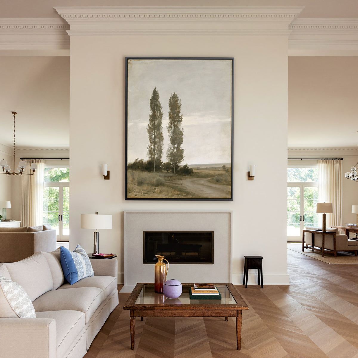 two slender poplar trees beside a curving dirt canvas wall art in a black frame above a mantel