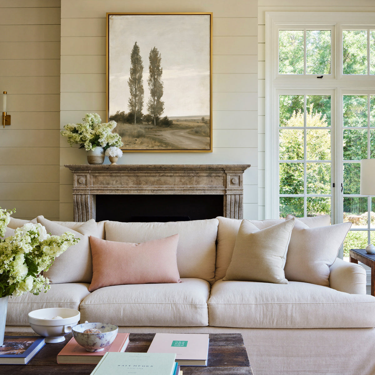 two slender poplar trees beside a curving dirt canvas wall art in a gold frame above a mantel