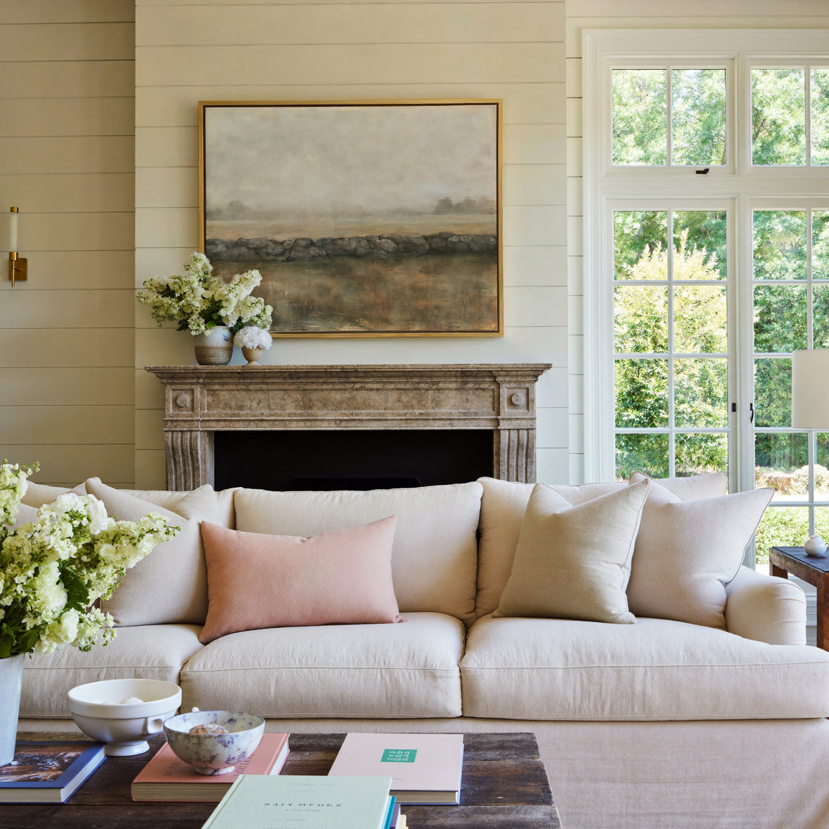 low stone wall across a hazy field canvas wall art in a gold frame above a mantel