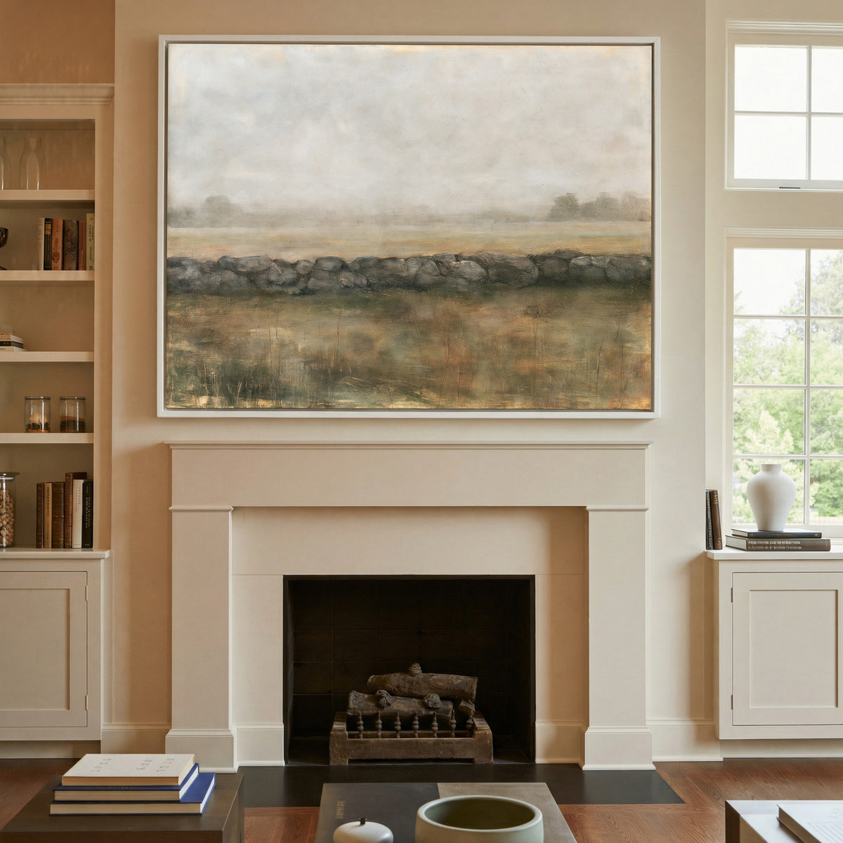 low stone wall across a hazy field canvas wall art in a white frame above a mantel