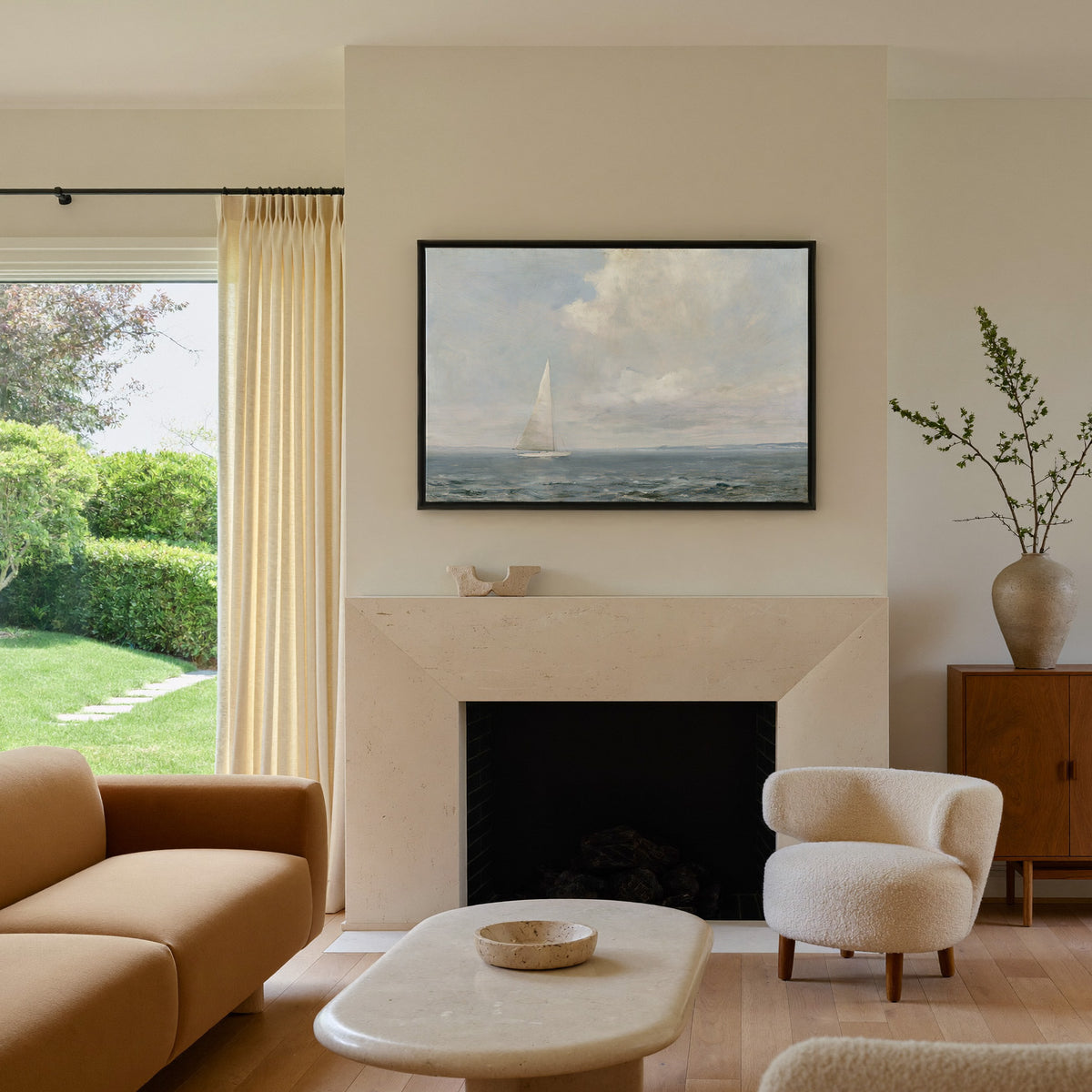 white sailboat beneath a pale oversized cloud canvas wall art in a black frame above a mantel