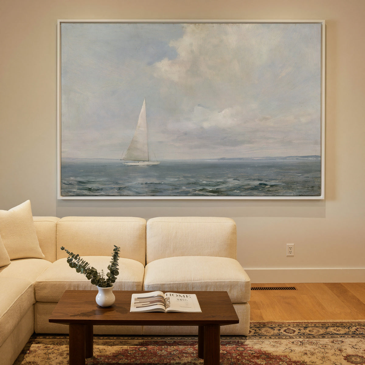 white sailboat beneath a pale oversized cloud canvas wall art in a white frame in a styled room setting