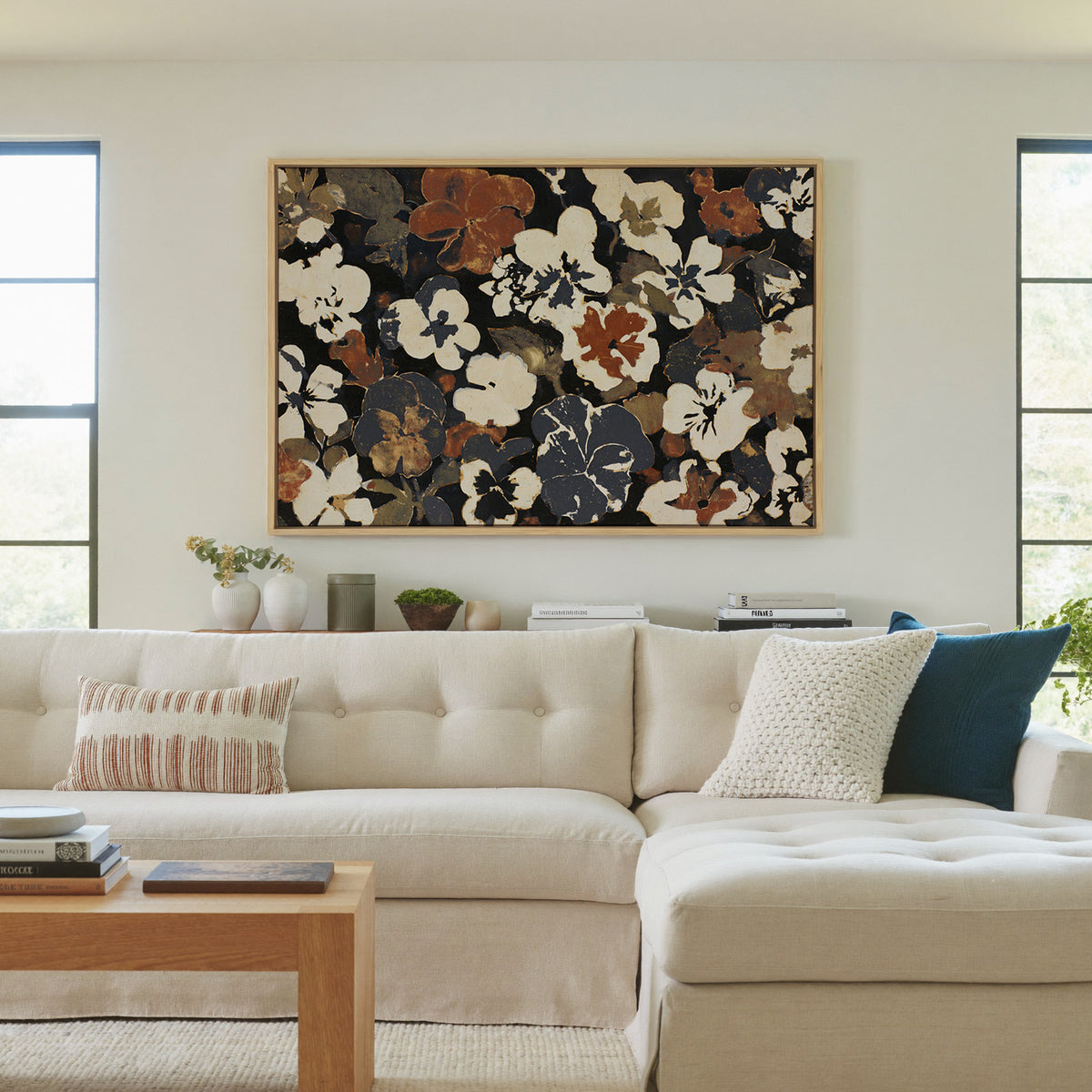 dark meadow flowers in cream, rust, and charcoal canvas wall art in a natural wood frame in a living room