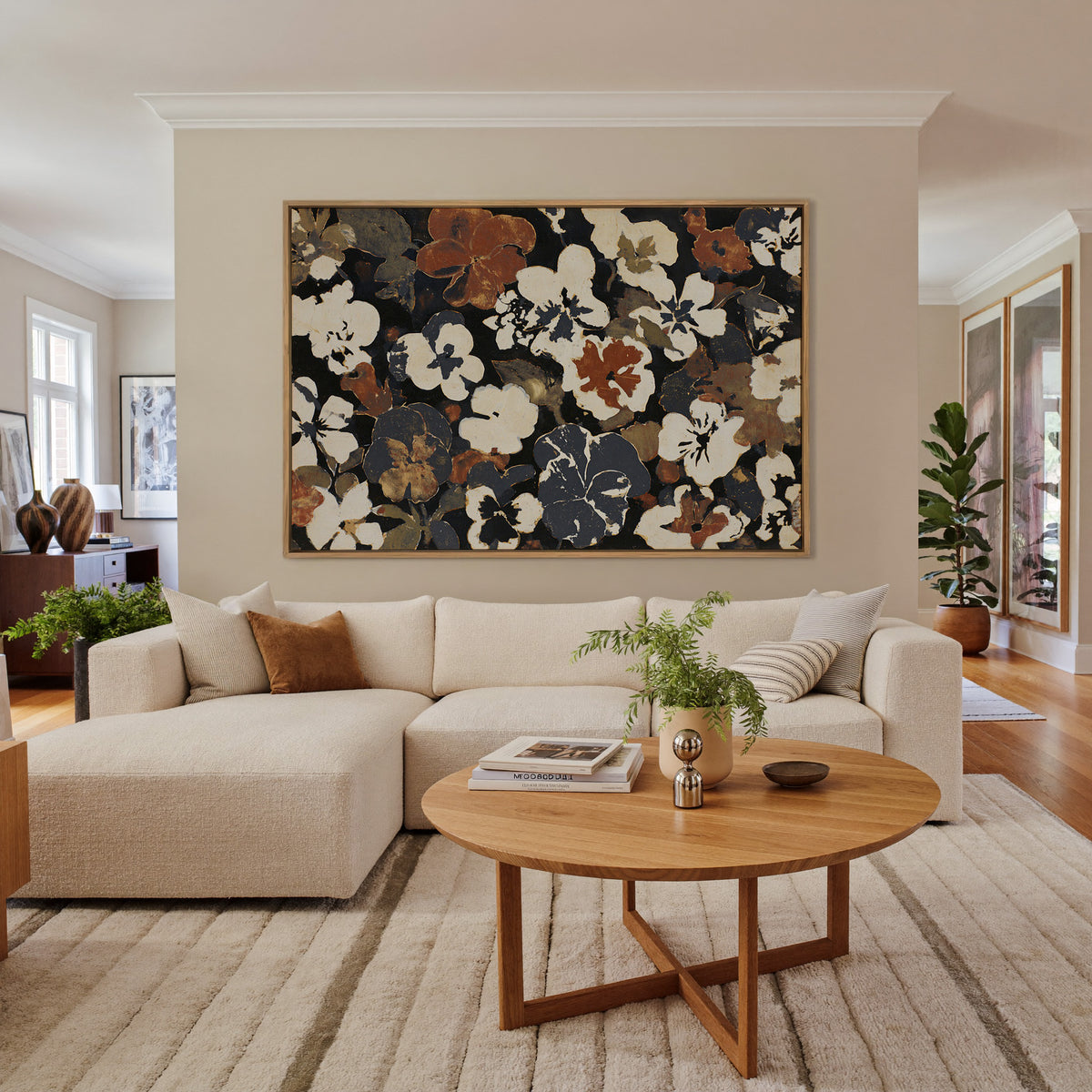 dark meadow flowers in cream, rust, and charcoal canvas wall art in an oak frame in a living room