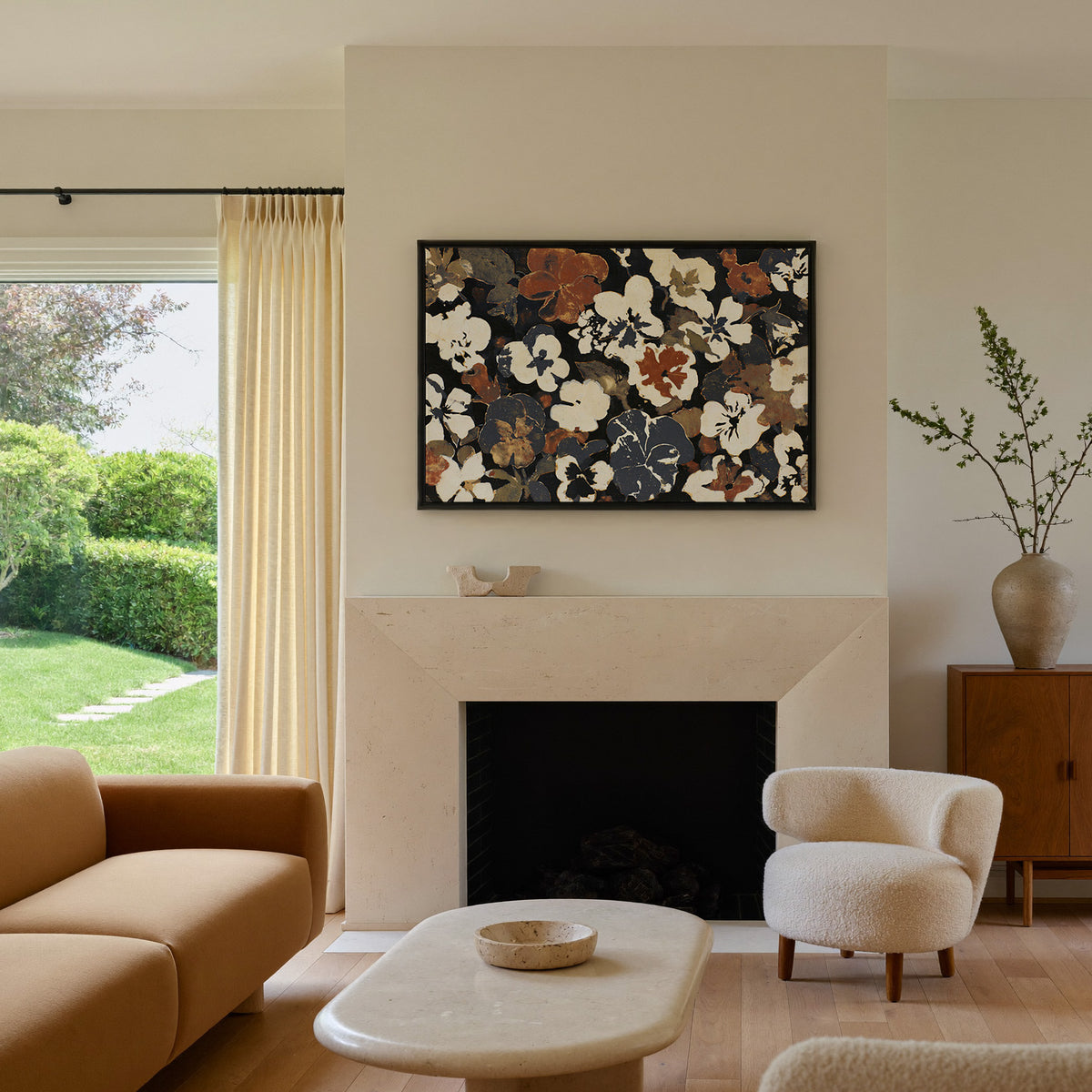 dark meadow flowers in cream, rust, and charcoal canvas wall art in a black frame above a mantel