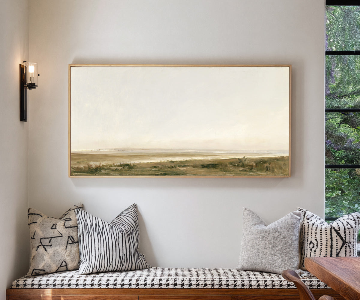 pale coastal landscape with low marshy ground canvas wall art in a natural wood frame in a living room