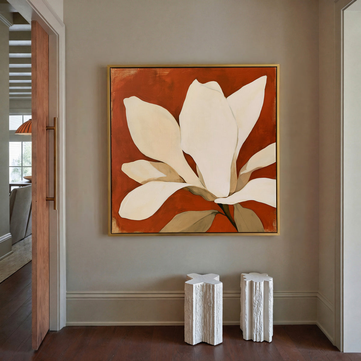 oversized ivory magnolia against terracotta canvas wall art in a gold floater frame in a styled room setting