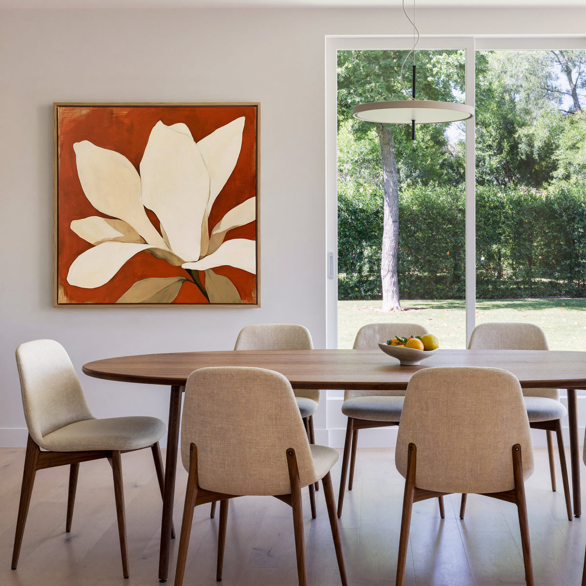 oversized ivory magnolia against terracotta canvas wall art in an oak finish floater frame in a dining room
