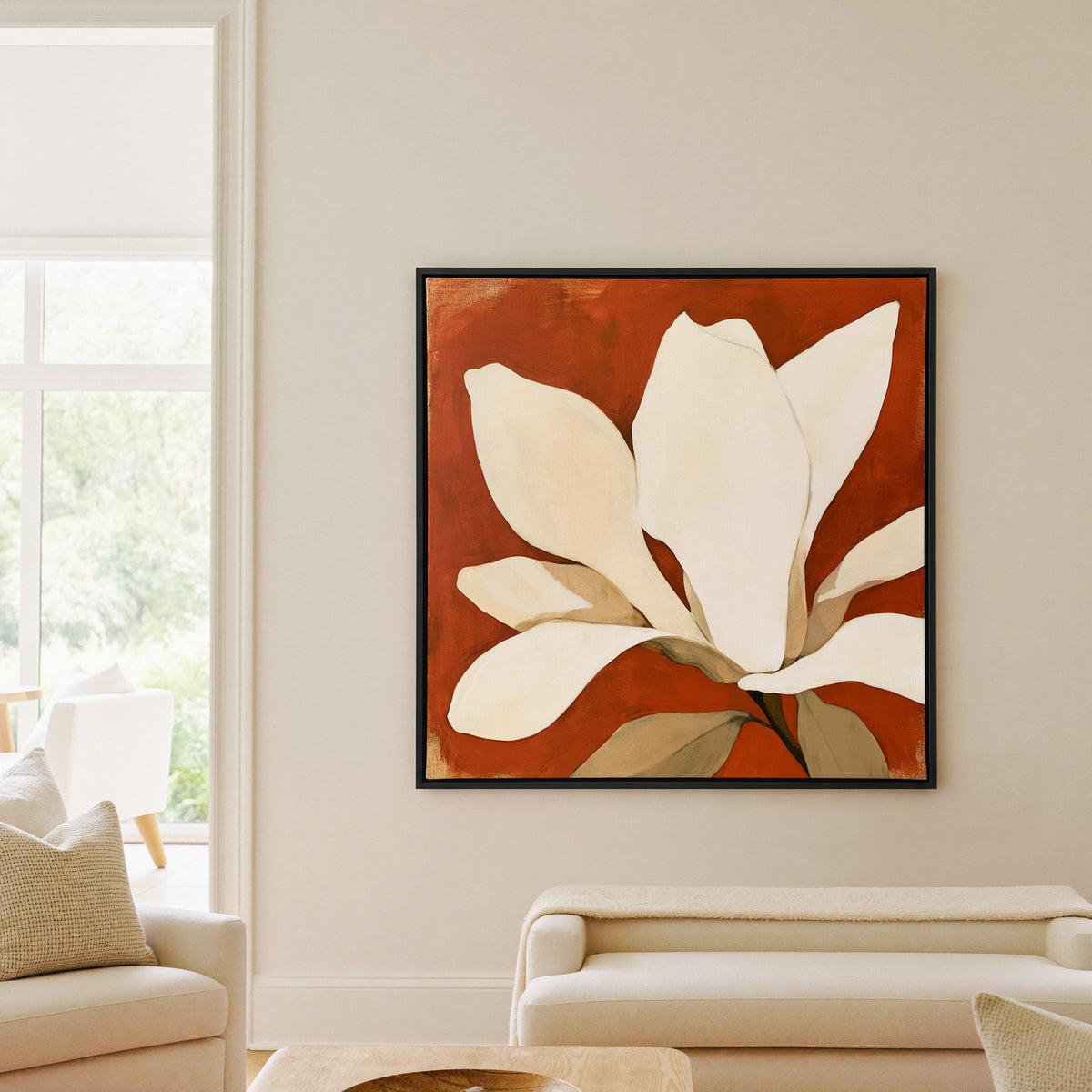 oversized ivory magnolia against terracotta canvas wall art in a black floater frame in a living room