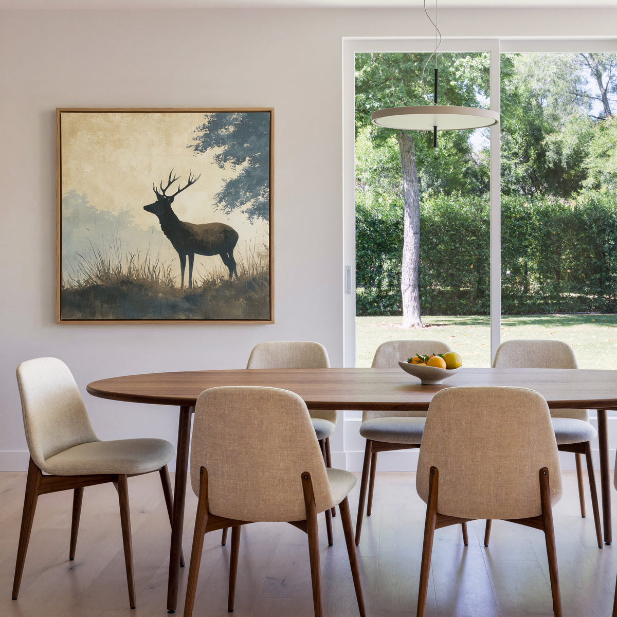 stag in profile beneath blue gray woodland canvas wall art in an oak finish floater frame in a dining room