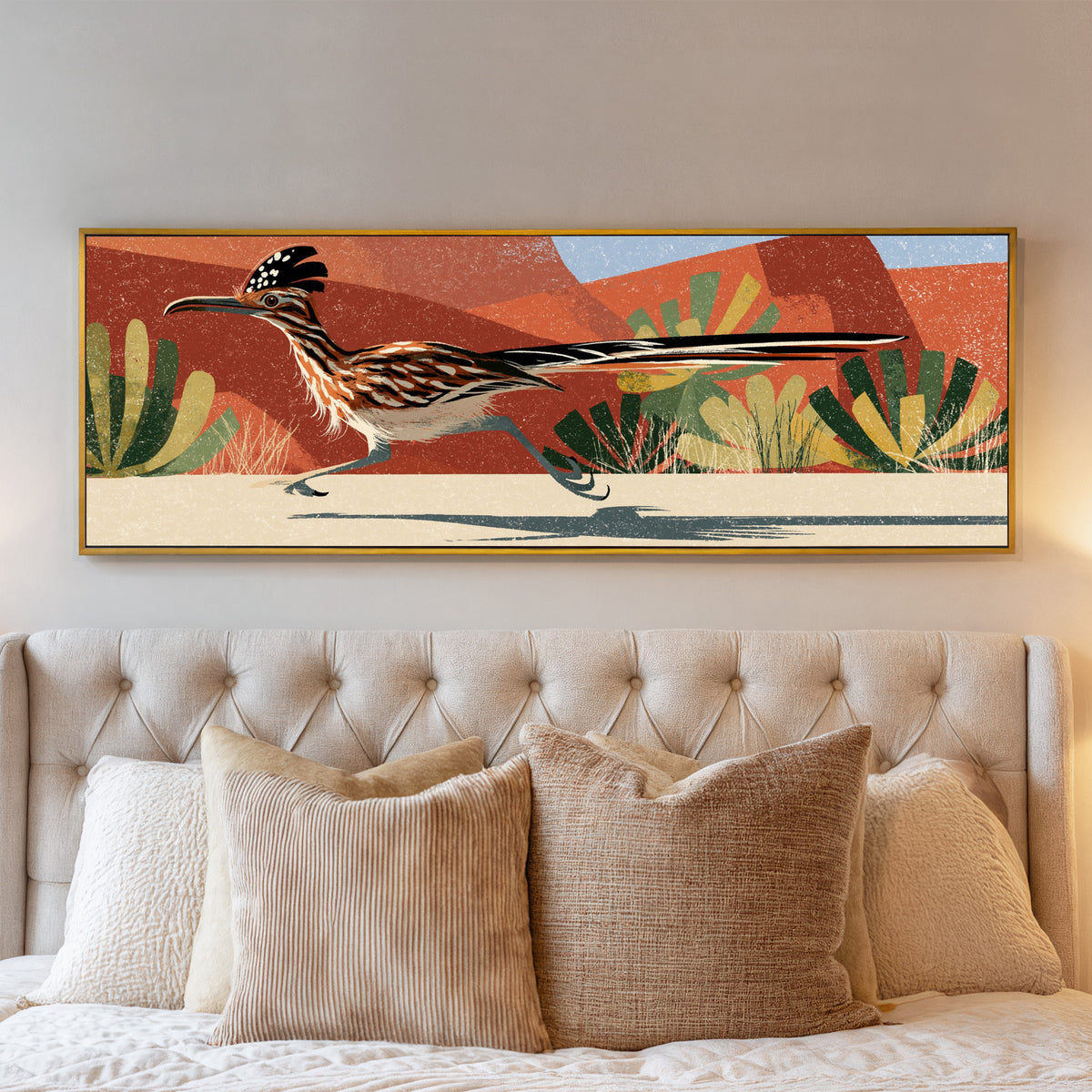 long tailed roadrunner crossing terracotta canvas wall art in a gold floater frame above a bed