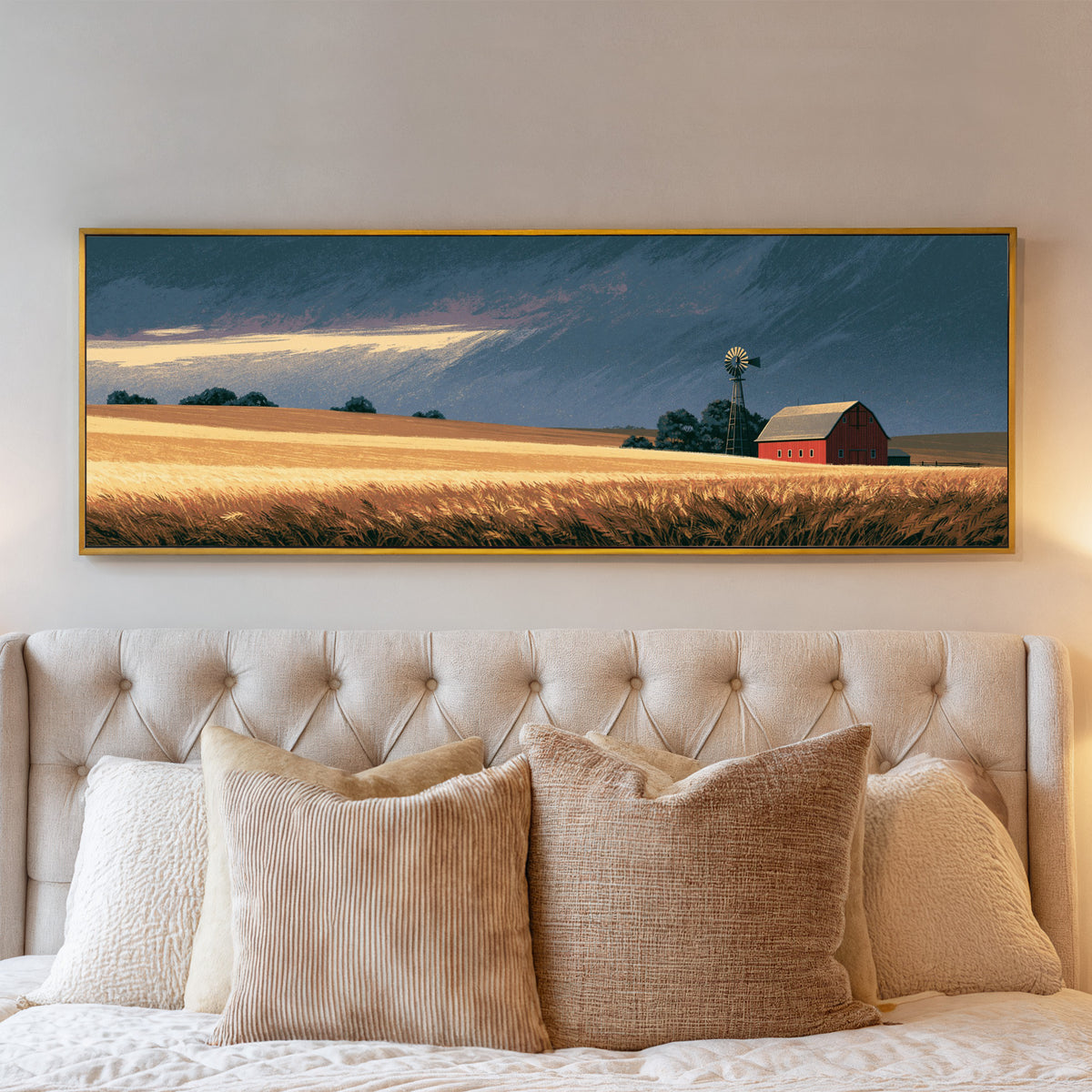 red barn and windmill across golden prairie canvas wall art in a gold floater frame above a bed