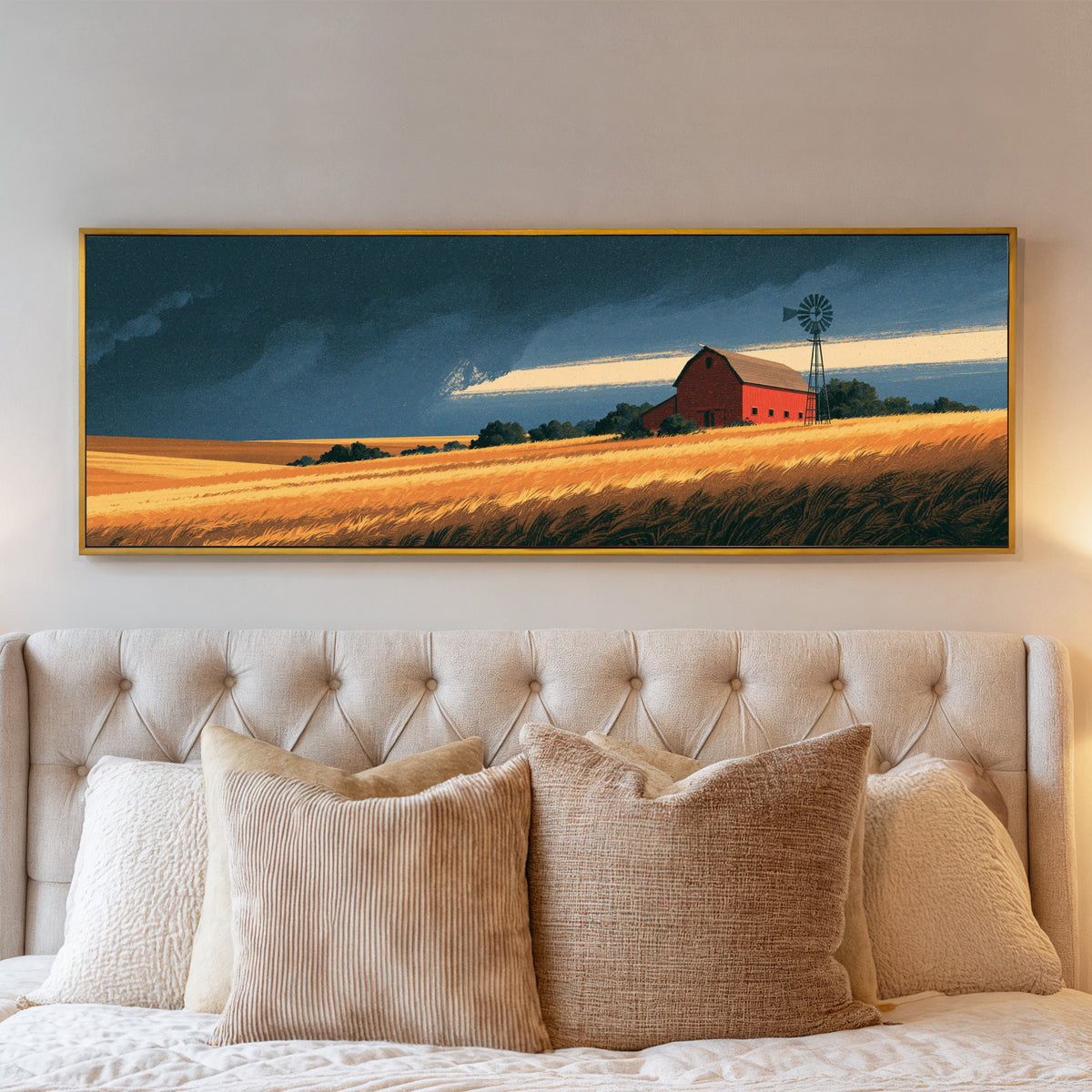 red barn and windmill above golden fields canvas wall art in a gold floater frame above a bed