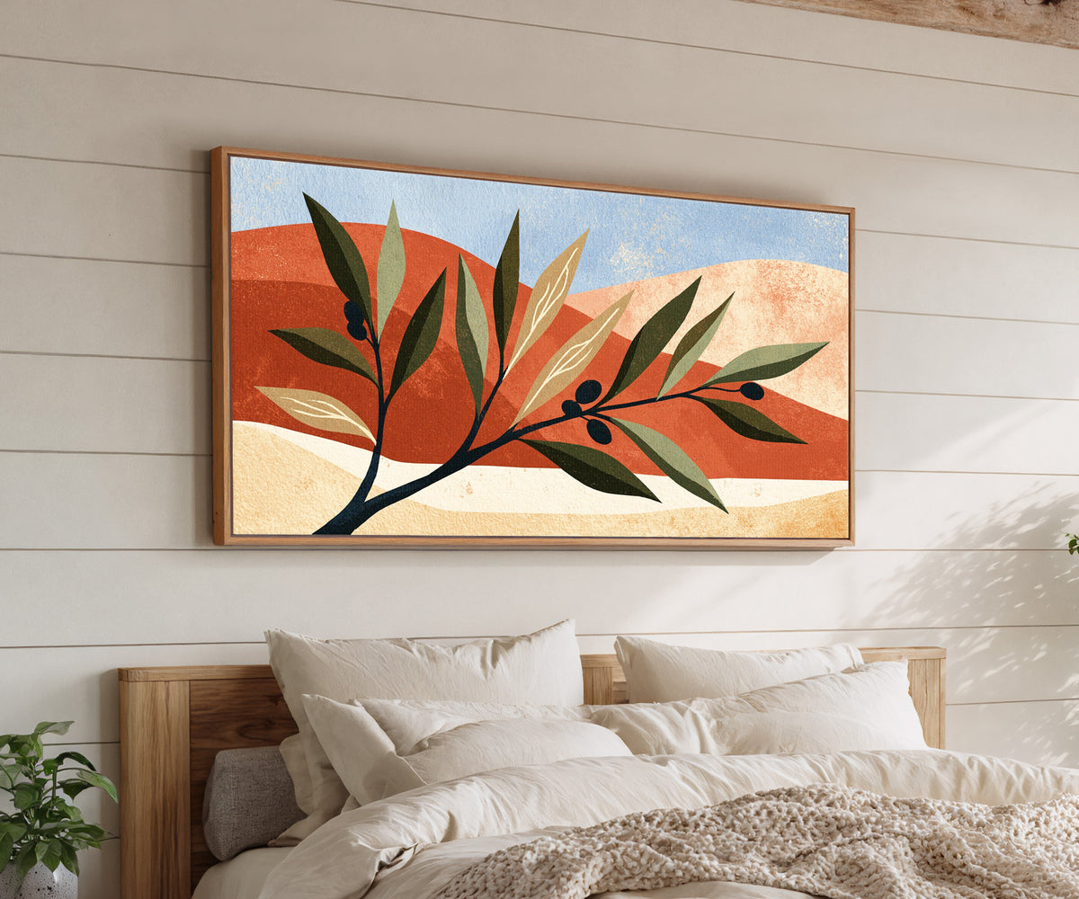 olive branch against terracotta curves and pale canvas wall art in an oak finish floater frame above a bed