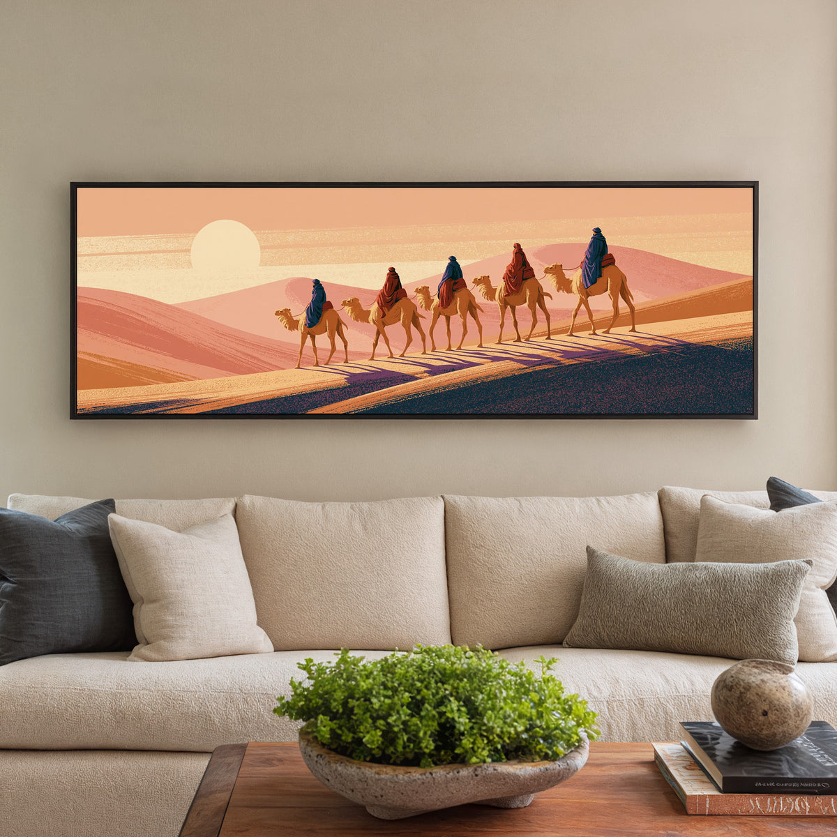 five camel riders crossing peach canvas wall art in a black floater frame in a styled room setting