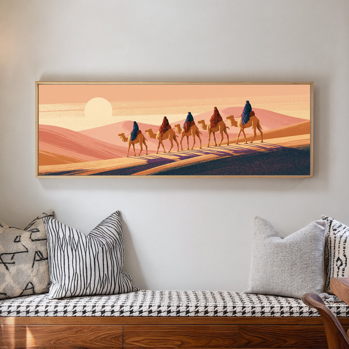 five camel riders crossing peach dunes beneath canvas wall art in a natural floater frame in a living room