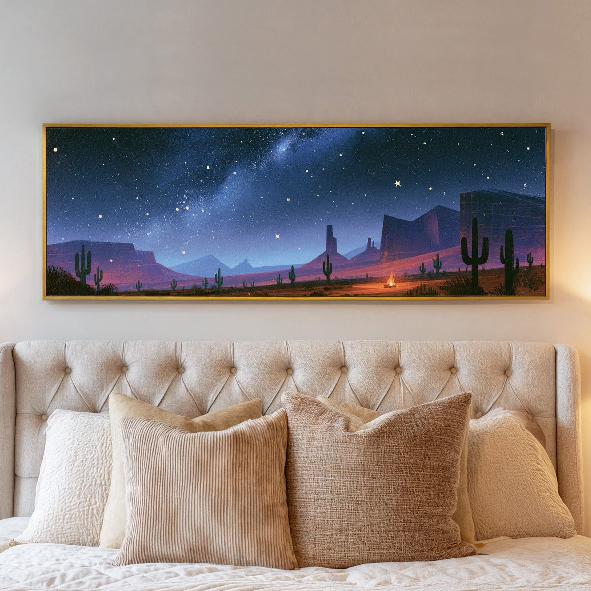 star filled blue sky above desert mesas, cactus canvas wall art in a gold floater frame above a bed