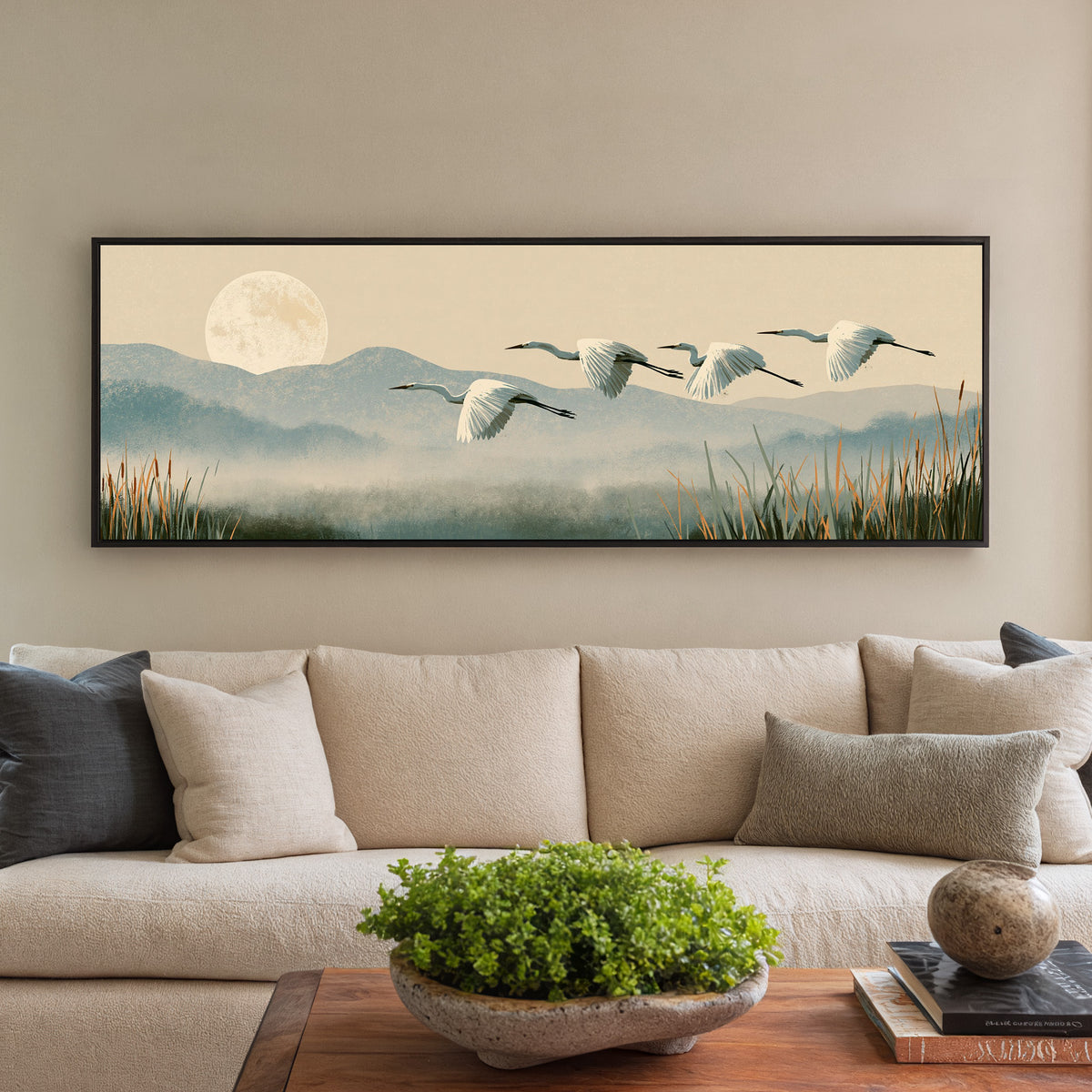four white egrets flying above canvas wall art in a black floater frame in a styled room setting