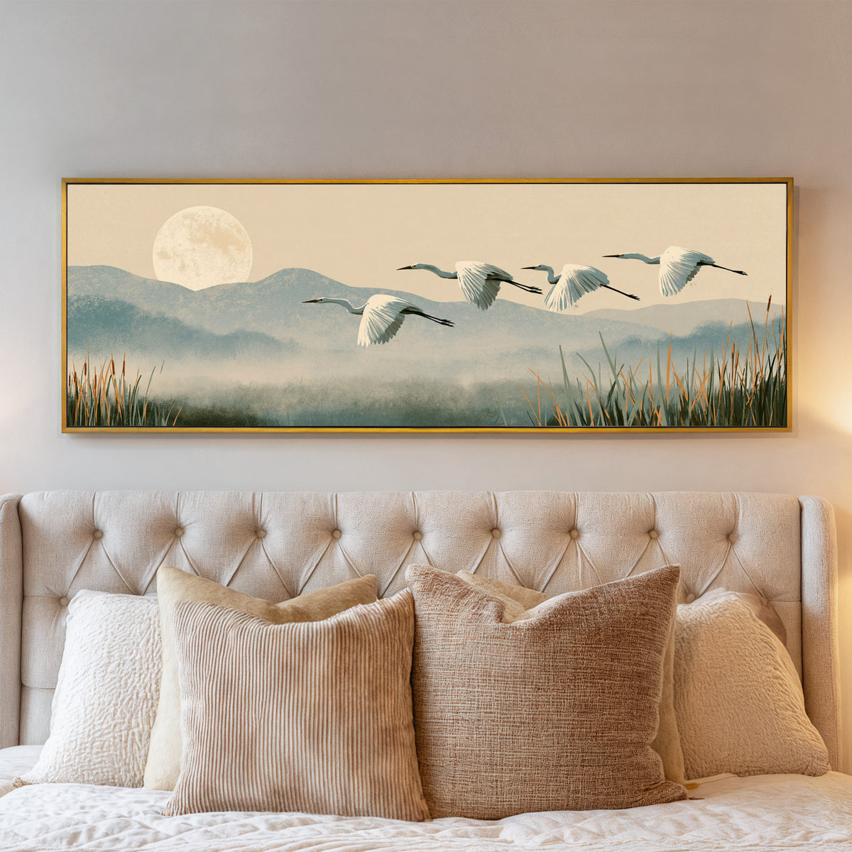 four white egrets flying above misty blue hills canvas wall art in a gold floater frame above a bed