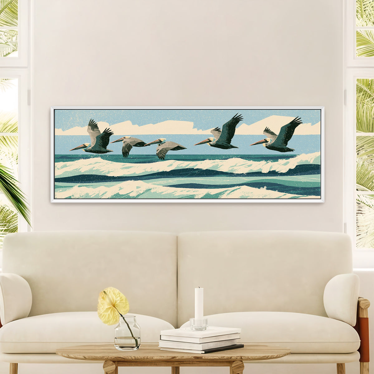five brown pelicans flying over teal surf canvas wall art in a white floater frame in a styled room setting