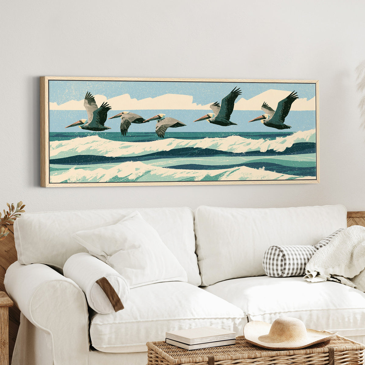 five brown pelicans flying over canvas wall art in an oak finish floater frame in a styled room setting