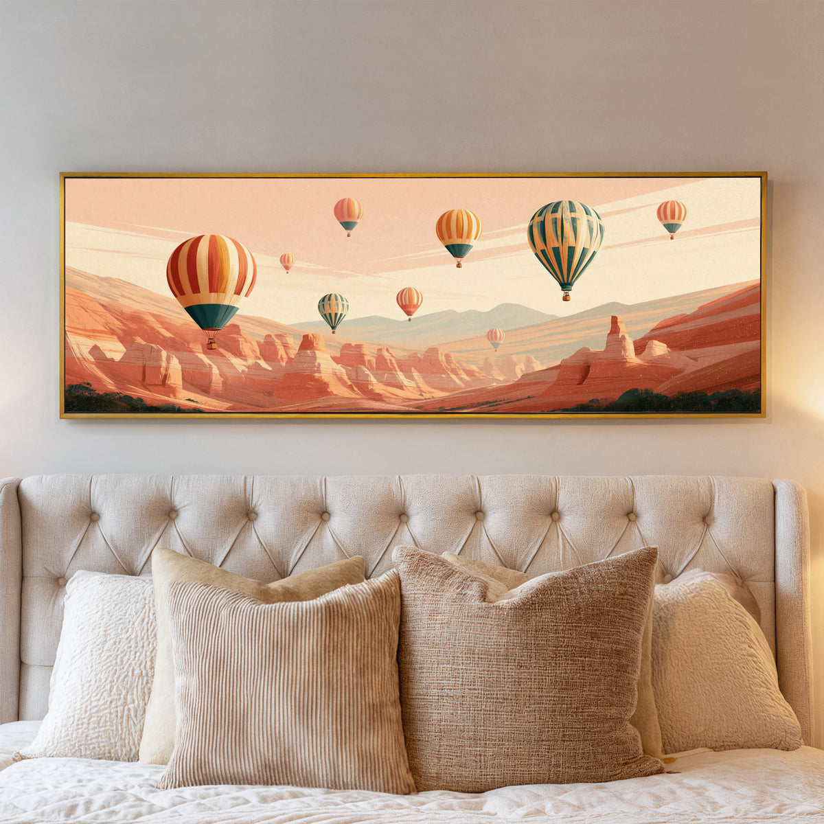 striped hot air balloons above a terracotta canvas wall art in a gold floater frame above a bed