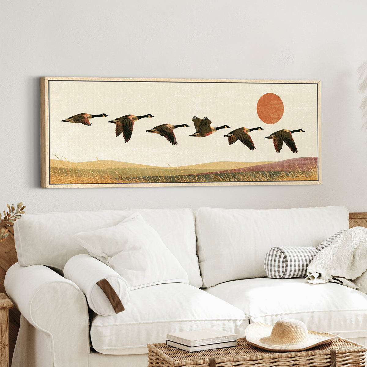 six canada geese flying over canvas wall art in an oak finish floater frame in a styled room setting