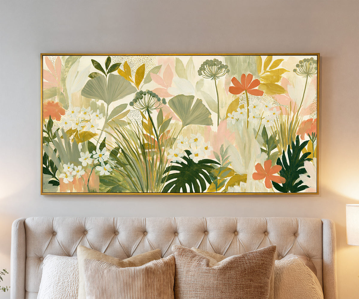 white daisies and coral flowers among layered canvas wall art in a gold floater frame above a bed