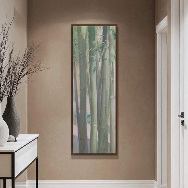This vertical canvas print features a serene bamboo forest rendered in a soft, impressionistic style with a predominantly green and pale blue palette, hanging on a taupe wall above a.