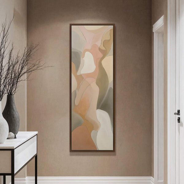 This vertical canvas wall art features an abstract organic subject in a soft palette of peach, beige, and grey, displayed within a natural wood floater frame on a beige wall.