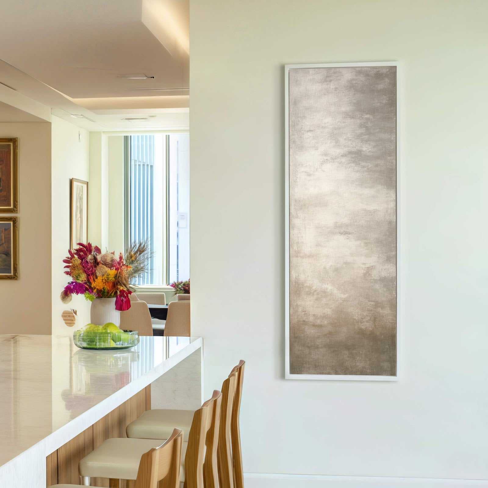A vertical canvas wall art print features abstract textures in a soft, muted palette, framed in white and displayed on a pale wall above a console table.