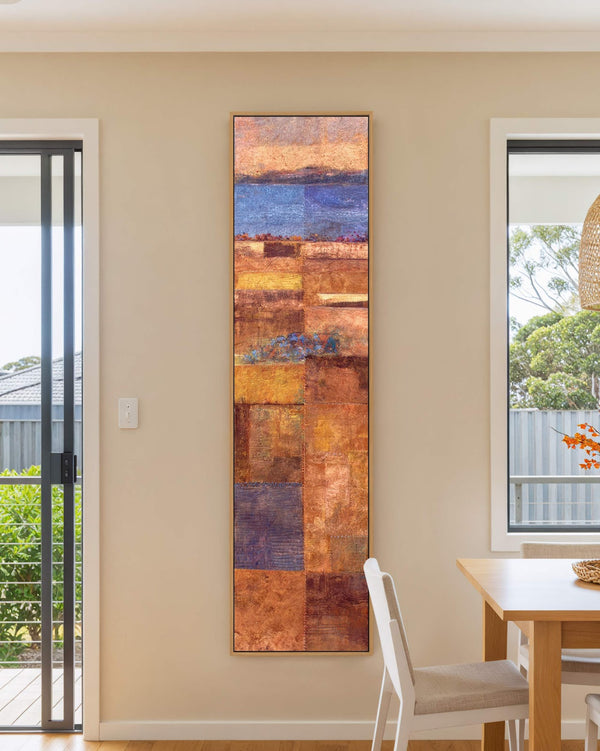 Vertical canvas wall art in interior setting.