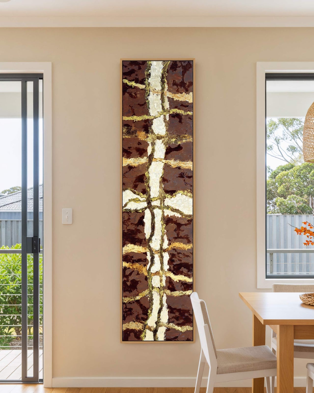 Vertical canvas wall art in interior setting.