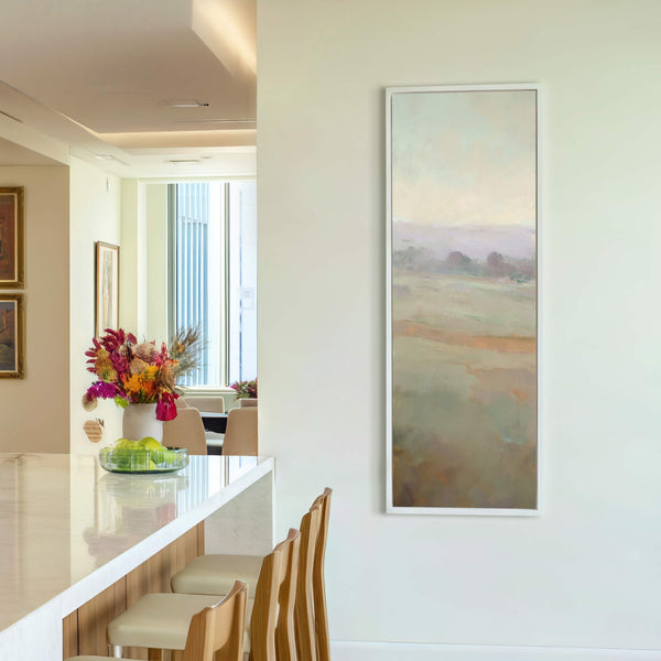 This vertical art print depicts a serene landscape with a soft palette of greens, blues, and purples. The canvas wall art is framed with a slim white floater frame and.