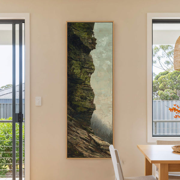 This vertical canvas print features a textured, impressionistic depiction of a mossy cliff face with a muted, earthy color palette, framed in a natural wood floater frame and displayed on.