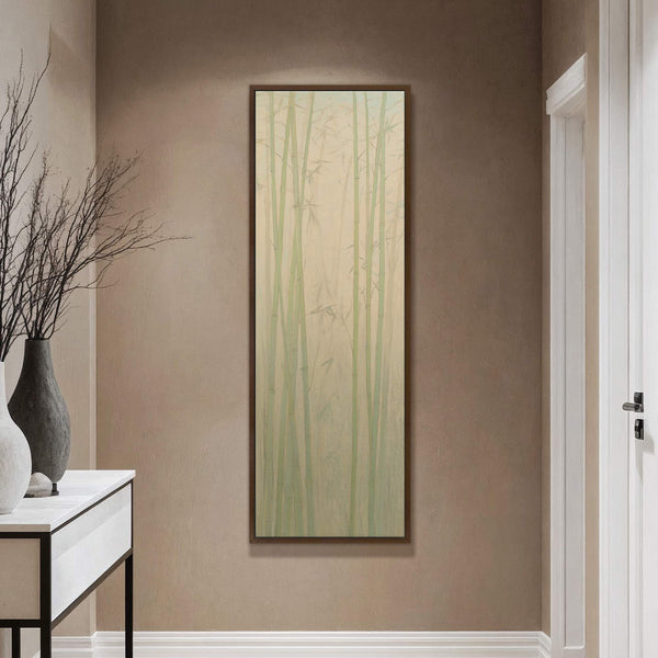 This vertical canvas wall art features a serene bamboo forest in a soft, pastel palette and minimalist style, hanging on a textured tan wall above a console table with decorative.