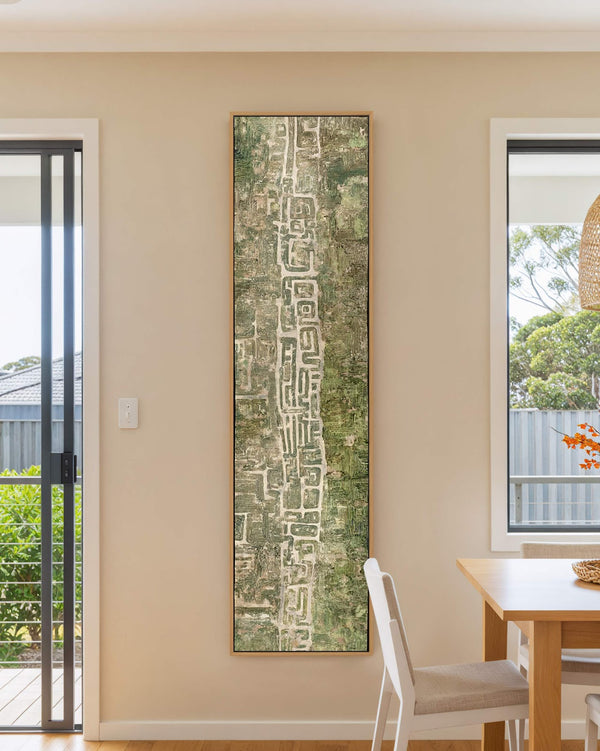 Vertical canvas wall art in interior setting.