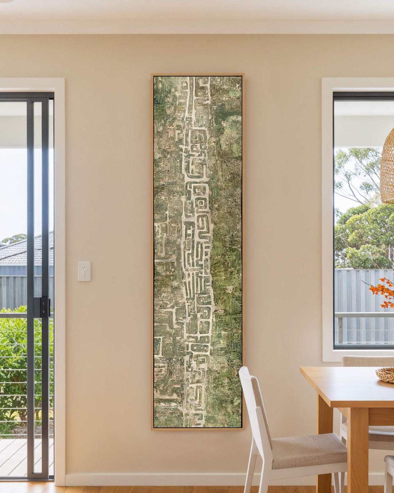 Vertical canvas wall art in interior setting.