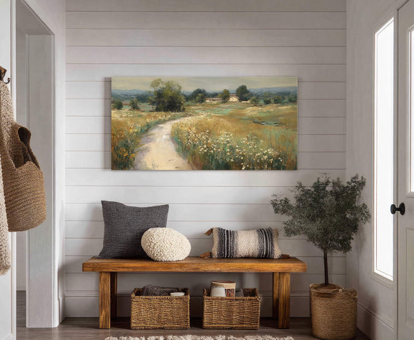 This horizontal canvas wall art displays a pastoral landscape with a winding path through fields of wildflowers, rendered in earthy tones. It is set in a hallway with white horizontal.