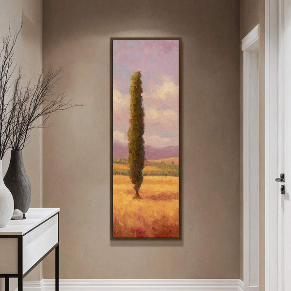 This vertical canvas wall art depicts a lone cypress tree in a field of golden wheat under a pink and yellow sky, rendered in an impressionistic style. It is displayed.