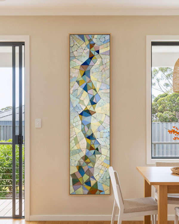 Vertical canvas wall art in interior setting.