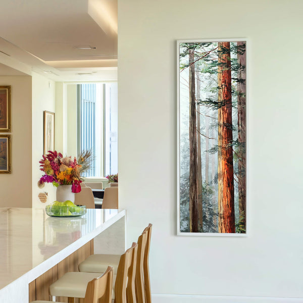 This vertical art print features a watercolor painting of tall redwood trees with warm orange trunks against a misty green background, framed in white and displayed on a white wall.