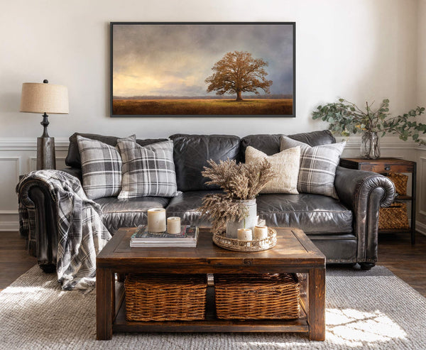 This horizontal canvas wall art features a textured, painterly style with a warm, earthy palette of the solitary oak tree set against a dramatic, cloudy sky and golden field, displayed.