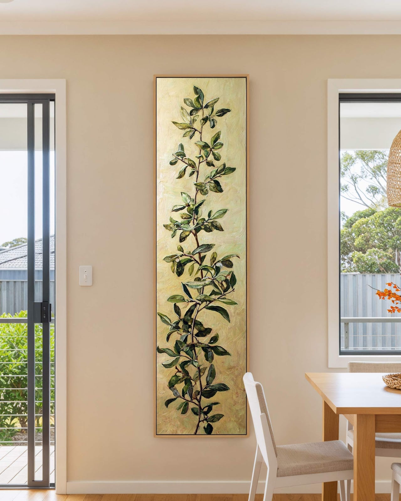 Vertical canvas wall art in interior setting.