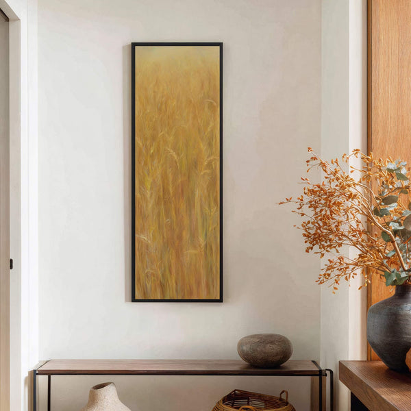This vertical canvas wall art features a warm, impressionistic depiction of golden wheat fields in a painterly style, set against a textured white wall above a dark wood console table.