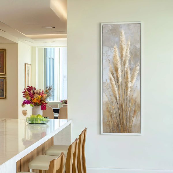 This vertical canvas wall art features a textured painting of pampas grass in earthy tones, displayed on a white wall above a kitchen island with bar with bar stools.