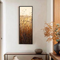 This vertical canvas wall art features reeds in a painterly style with a warm, earthy palette, displayed on a white wall above a console table.