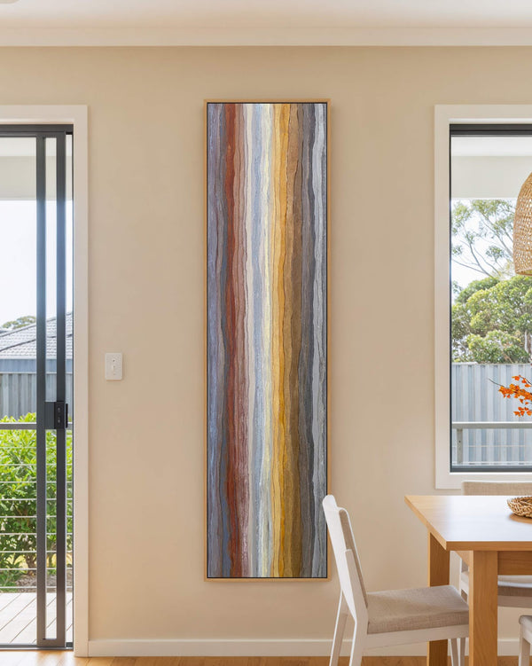 Vertical canvas wall art in interior setting.